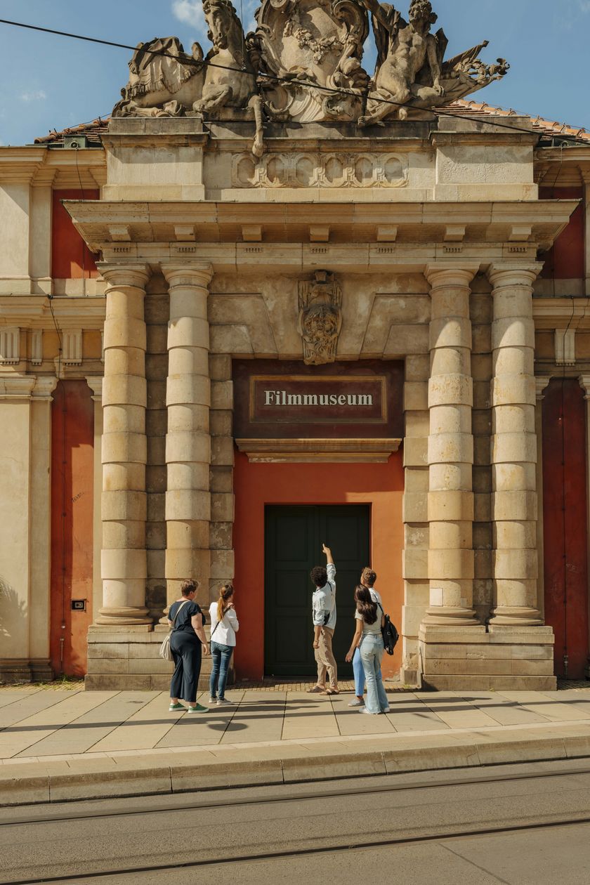 A small group is standing in front of the Potsdam Film Museum